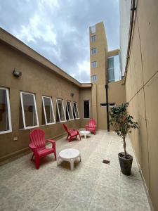 un balcón con sillas rojas y una mesa en un edificio en Eco Plaza Hotel en Salta