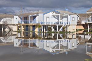 a house in the water with its reflection at Pavillon Grazel GRUISSAN in Gruissan