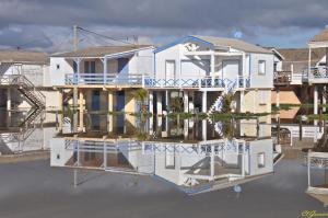una casa en el agua con su reflejo en Pavillon Grazel GRUISSAN, en Gruissan