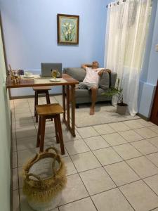 a man sitting on a couch in a living room at La Estancia Ideal Apartamentos in Fortuna