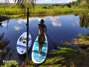 Twee jongens staan op een paddleboard in het water. bij Room in Lodge - Method Living Tropical Edition in Cabarete