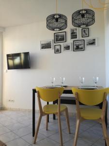 ein Esszimmer mit 2 gelben Stühlen und einem Tisch in der Unterkunft Bel appt T2 4p confortable avec vue mer imprenable in Narbonne-Plage