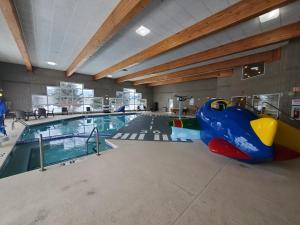 una gran piscina cubierta con tobogán. en Cobblestone Suites - Oshkosh, en Oshkosh