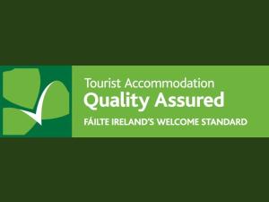 a sign that reads tourist accommodationquality assured with a green background at No 12 B&B in Dungarvan