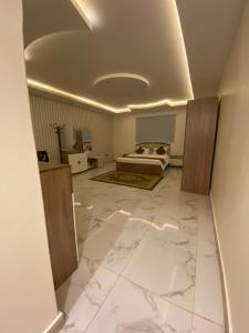 a bedroom with a bed and a white marble floor at شاليهات لودج in Al Humaizah