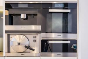 a trio of stainless steel ovens in a cabinet at Villa Louise Oostende in Ostend