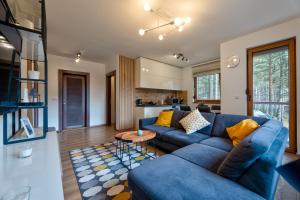 ein Wohnzimmer mit einem blauen Sofa und einem Tisch in der Unterkunft Apartman Neva Zlatibor in Zlatibor