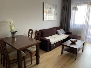 ein Wohnzimmer mit einem Sofa und einem Tisch in der Unterkunft ApartmanTatryView in Veľká Lomnica