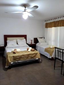 1 dormitorio con 2 camas y ventilador de techo en Departamentos Maryan en San Luis