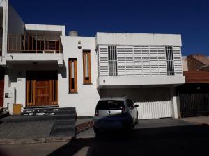 a car parked in front of a white house at Departamentos Maryan in San Luis