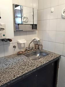 a kitchen counter with a sink and a mirror at Departamentos Maryan in San Luis