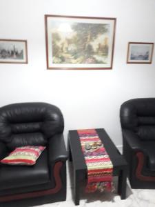sala de estar con silla y mesa en Departamentos Maryan en San Luis