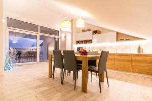 uma cozinha e sala de jantar com uma mesa de madeira e cadeiras em B&B COL DE LE MOLE - DOLOMITI BELLUNESI em Belluno