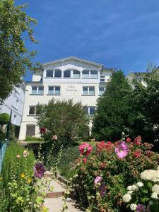 a white building with flowers in front of it at Villa Victoria mit Meerblick in Sassnitz