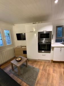 a kitchen with white cabinets and a table in a room at Le Duplex du Lac in Évian-les-Bains