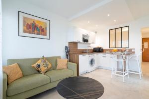 a living room with a couch and a table and a kitchen at Coup de coeur! Vue mer! Terrasse dangle! in Antibes +7 photos