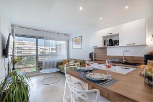 a kitchen and living room with a table and chairs at Coup de coeur! Vue mer! Terrasse dangle! in Antibes