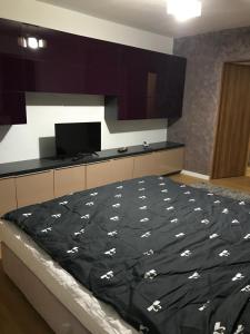 um quarto com uma cama com um edredão preto em L&A apartments - Circumvalatiunii em Timisoara