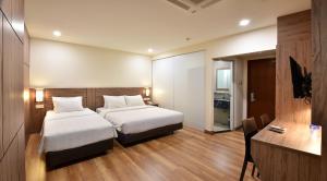 a hotel room with two beds and a desk at YANGTZE HOTEL 长江酒店 in Johor Bahru