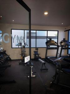ein Fitnessstudio mit mehreren Laufbändern in einem Raum mit Fenstern in der Unterkunft Cozy Family Vacation Home near the beach! in Playa del Carmen