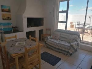 sala de estar con mesa y sofá en Die Waenhuis, en Arniston