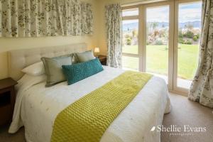a bedroom with a bed and a large window at Night Sky Cottages - Kea Cottage - LUXURY in Twizel +27 photos