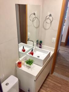 a bathroom with a white sink and a mirror at La Fleur Polinésia Muro Alto in Porto De Galinhas