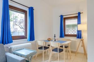 comedor con cortinas azules, mesa y sillas en Peters Guest House, en Bolzano