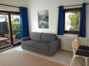 una sala de estar con un sofá y una silla en Peters Guest House, en Bolzano
