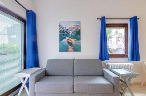 sala de estar con sofá y cortinas azules en Peters Guest House, en Bolzano