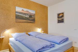 ein Bett mit zwei blauen Kissen darüber in der Unterkunft Peters Guest House in Bozen