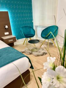 a bedroom with two blue chairs and a bed at Appart' Weekly Quartier Impérial Gare in Metz