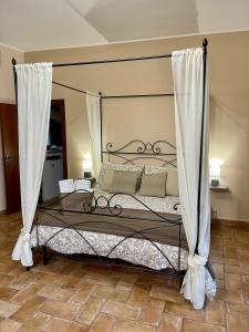 a bedroom with a canopy bed with white curtains at Casa Vacanze La Piazzetta del Castello in Montecalvello