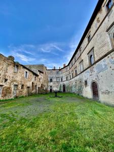an old building with a grass yard in front of it at Casa Vacanze La Piazzetta del Castello in Montecalvello