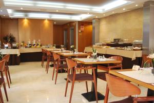 un ristorante con tavoli e sedie in legno e un buffet di Hotel RH Sorolla Centro a Valencia