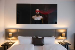 a bedroom with a bed with a portrait of a man at Wyndham Stuttgart Airport Messe in Stuttgart