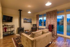 a living room with a couch and a fireplace at Night Sky Cottage - Kahu Cottage - HOT TUB in Twizel