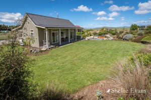a house with a large lawn in front of it at Night Sky Cottage - Kahu Cottage - HOT TUB in Twizel