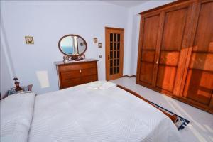 a bedroom with a bed and a dresser and a mirror at La Villa del Pixus in Pisciotta