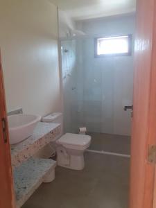 a bathroom with a sink and a toilet and a shower at Vila Figueiredo das Donas - Suíte Espaço Gourmet in Bombinhas