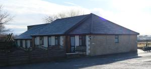 a small brick house with a black roof at The Old Rectory - Brean in Brean