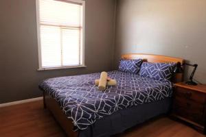um urso de peluche sentado numa cama num quarto em Silver City Oasis em Broken Hill