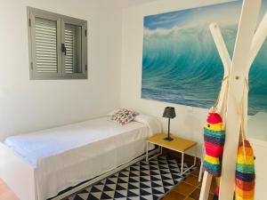 a bedroom with a bed and a painting of the ocean at Blue Marlin 6 in Pasito Blanco