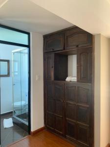 a room with a large wooden closet with a glass door at Hotel Santa Elena Norte in Tunja