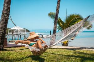 a woman sitting in a hammock on the beach at Orpheus Island Lodge in Orpheus Island