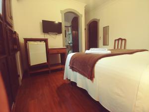 een slaapkamer met een bed, een bureau en een spiegel bij Pousada Casa dos Contos in Ouro Preto