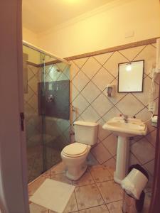 a bathroom with a toilet and a sink and a shower at Pousada Casa dos Contos in Ouro Preto