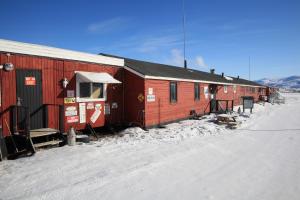 a red and white train is parked on the tracks at Old Camp in Kangerlussuaq