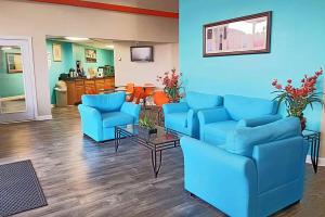 una sala de estar con sofás azules y una mesa. en Howard Johnson by Wyndham Houston Hobby en Houston
