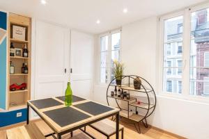 a dining room with a table and chairs and windows at Appartement T2 Cosy Honfleur CityStay COEUR HONFLEUR Netflix Wifi in Honfleur
